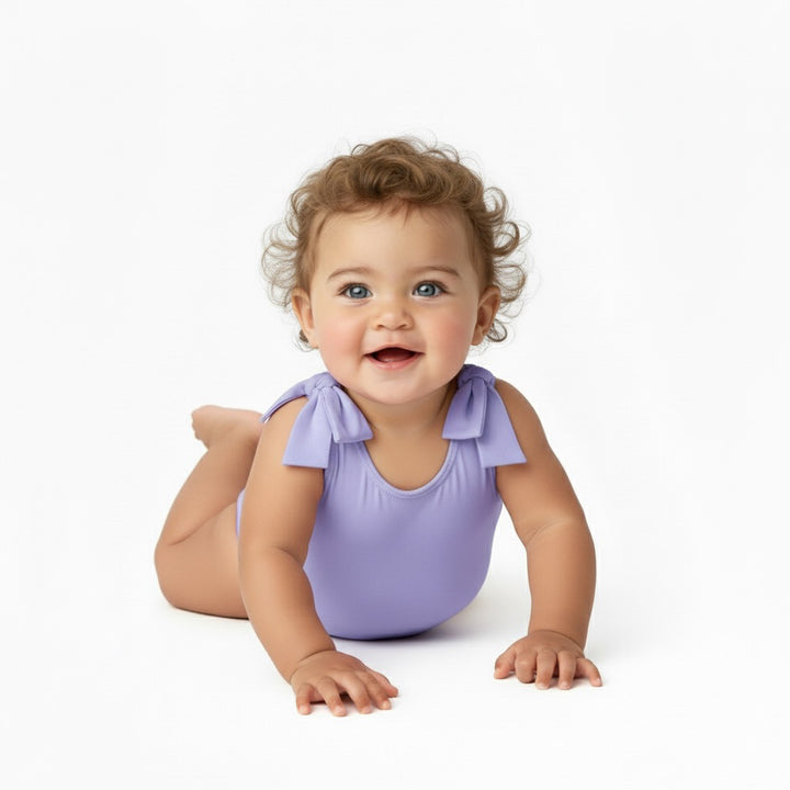 Baby crawling and smiling in a Motch Lavender bow-shoulder bodysuit — soft, flexible, and made for movement, designed for adorable everyday mommy-and-me matching moments.